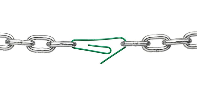 close up of a broken chain and a paper clip on white background.jpeg